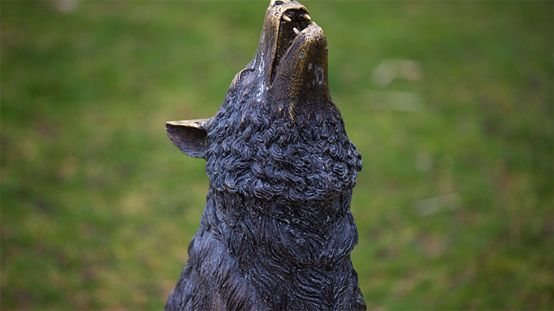 a bronze statue of a wolf howling 